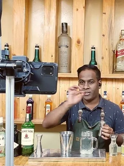 Demonstrating the finer points of adding a garnish during a virtual session. My goal is to teach the techniques that elevate a simple drink into a true craft cocktail, focusing on both taste and presentation.