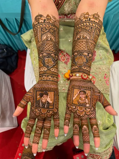 A close-up of a classic portrait mehndi. The palms feature beautifully detailed portraits of the bride and groom in their wedding attire, framed by traditional Rajasthani jharokha patterns. The fine lines and shading bring the portraits to life.