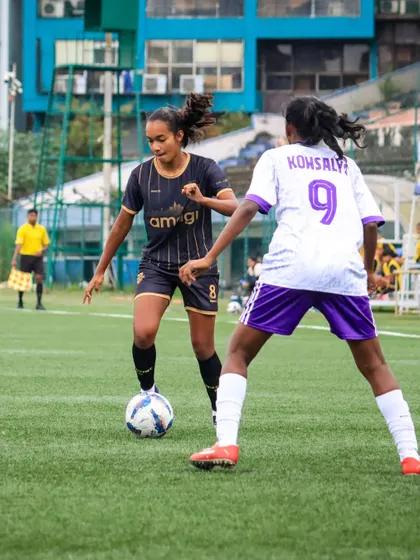 A player demonstrates excellent dribbling skills, confidently taking on a defender in a one-on-one situation during a youth championship match.