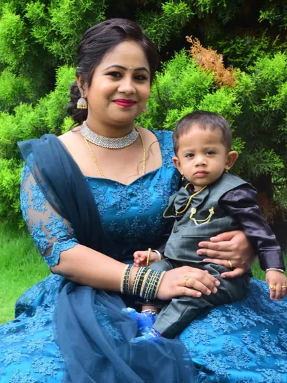 A sweet mother and son duo. The mother's blue lace gown and the son's smart tuxedo were designed to complement each other.