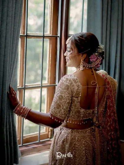 A view from the back, showing the lovely floral bun and the backless design of her blouse.