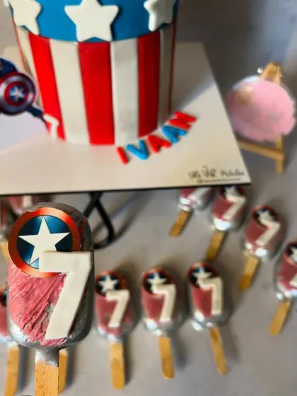 A detailed shot of the Captain America cakesicles, each decorated with the hero's shield and the birthday number.