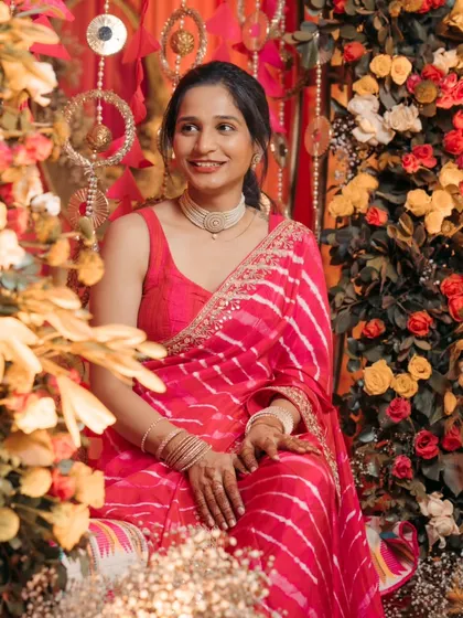 A beautiful portrait of the bride surrounded by a stunning floral arrangement at her mehndi. The vibrant colors and her serene expression make for a gorgeous shot.