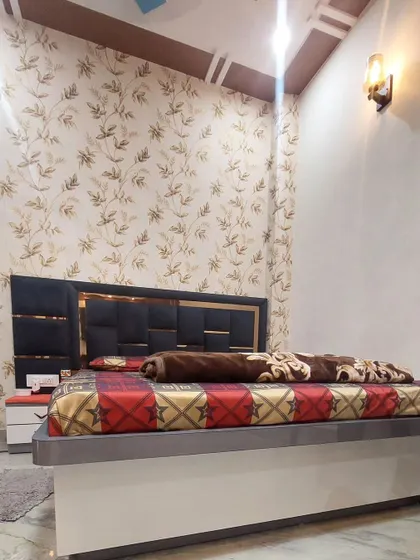 Another view of the bedroom, showing how the wallpaper and the bed's design work together. The wall-mounted light adds a warm, ambient glow.