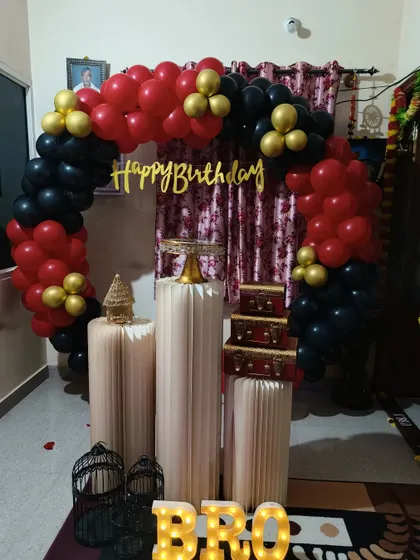 A bold red, black, and gold theme for a birthday celebration. This half-arch of balloons is set up in a home, showing how I can create an impactful decoration even in a smaller space.