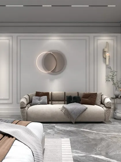 The seating area within the bedroom, featuring a plush sofa and a unique circular wall art piece. The design provides a comfortable space for relaxation, separate from the sleeping area.