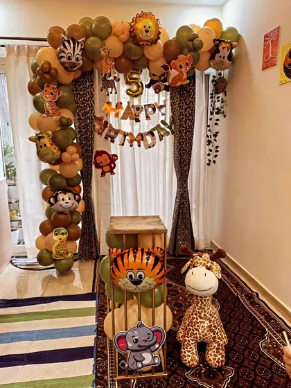 Let's go on a jungle safari. This theme uses earthy tones of olive green and brown balloons, animal print curtains, and cute animal foil balloons like a lion, zebra, and monkey to create a wild adventure for a 5th birthday.