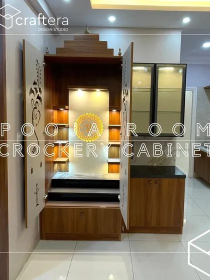 This pooja room is integrated with a crockery cabinet, making it a great space-saving solution. The mandir has beautiful CNC-cut doors and internal lighting to create a divine ambiance.