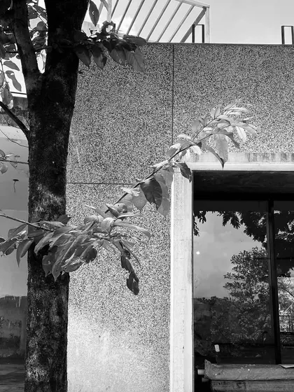 A black and white progress shot of Ridge House, focusing on the texture of the grit-finish walls and the reflections in the window.