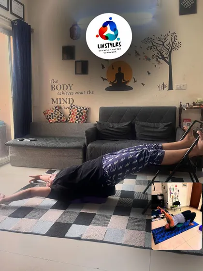 A client performs a restorative pose on a yoga chair, stretching his back and legs.