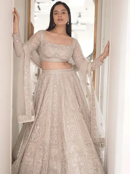 Dazzle in heritage elegance. A full shot of the intricately embellished ivory lehenga, woven with love to make you shine on your special day.