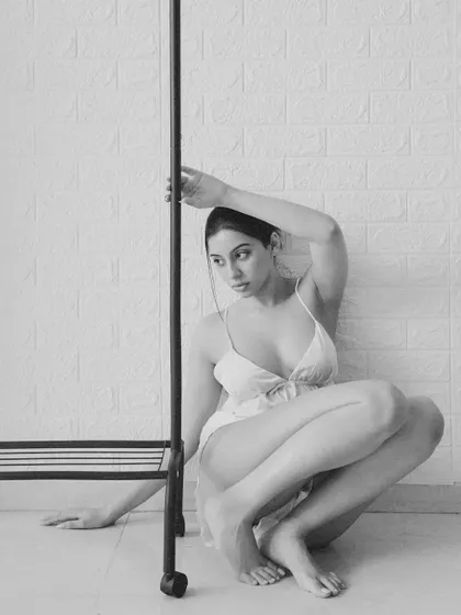 A more contorted, introspective pose. The black and white conversion enhances the moody, artistic feel of the shot.
