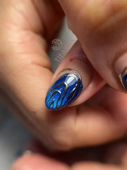 A single nail from the ocean luxury set, showing the detailed chrome work over the sparkling blue base.
