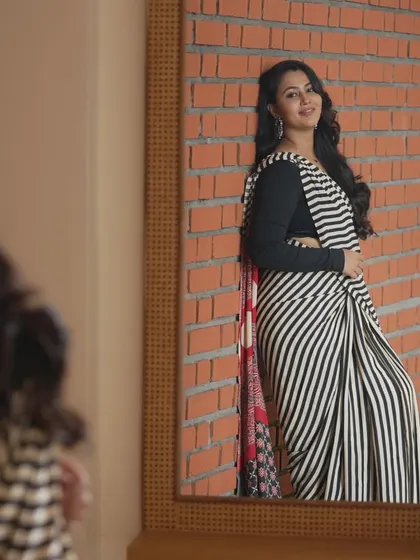 A modern take on saree styling. This look, featuring soft, flowing curls and natural makeup, shows how we can create a contemporary and chic style for photoshoots, corporate events, or family get-togethers.