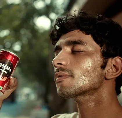 A close-up of a character enjoying a refreshing can of Nescafé Intense. The styling captures the feeling of relief and satisfaction on a hot day.