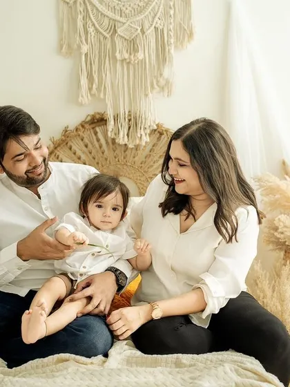 A candid moment of play. The parents' focus is entirely on their baby, creating a heartwarming scene that feels intimate and completely natural.