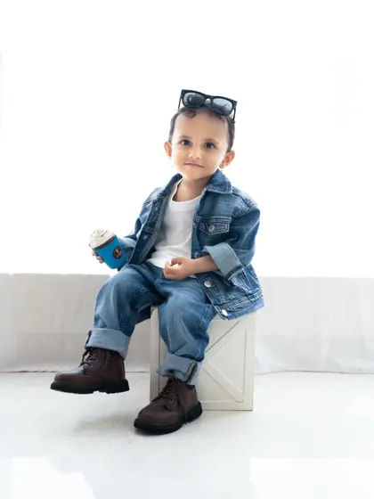 A cute portrait of the toddler with his sunglasses pushed up on his head.