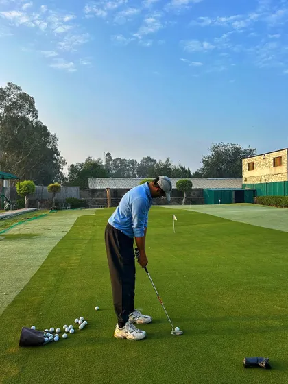 A golfer practices his putting on a pristine green, focused on sinking every shot.