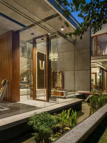This contemporary puja room at The Quarry House is a glass-enclosed sanctuary set over a water body. The design fosters a sense of tranquility and connection to the five elements.
