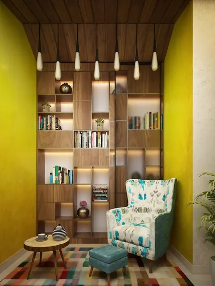 This reading nook is built into an alcove, with a floor-to-ceiling bookshelf that creates a library-like feel. The colorful armchair adds a touch of personality.