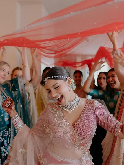 A fun, high-energy shot of the bride making her entrance. Her smile and her glowing makeup are the focus here.