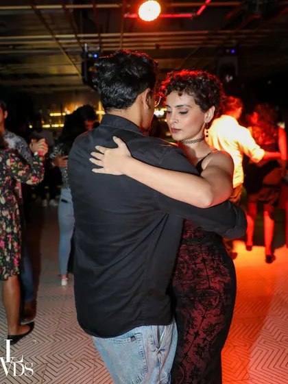 A beautiful, close embrace during a Tango or Kizomba dance. The low light and intimate setting are perfect for these styles.