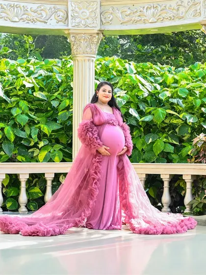 A beautiful solo portrait in a garden gazebo. The flowing pink gown and the elegant pillars create a very classic and romantic maternity photo.