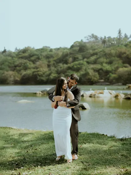 A warm embrace from behind, this portrait captures the couple's closeness and comfort with each other against a beautiful, green landscape.