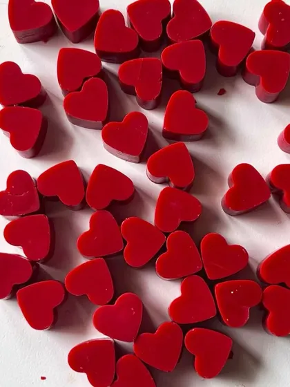 Bright red heart-shaped wax melts, ready to be packed. They have a beautiful, strong fragrance.