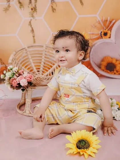 A happy, relaxed portrait of the birthday boy sitting amongst sunflowers, perfectly capturing the warmth of the theme.