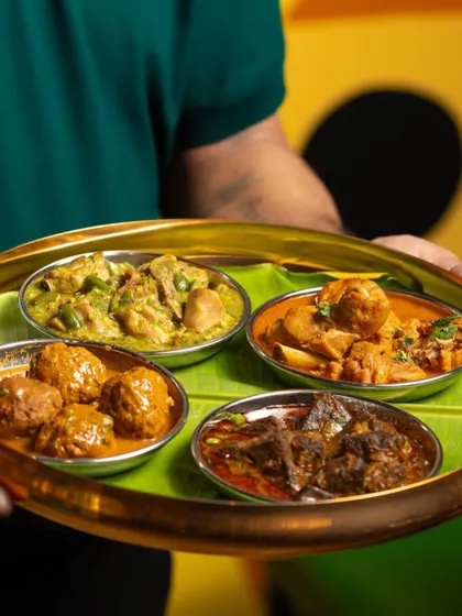 A platter showcasing a variety of my Naati curries. Each bowl holds a different preparation, from meatball curry to a rich mutton stew, highlighting the diversity of my regional cuisine.