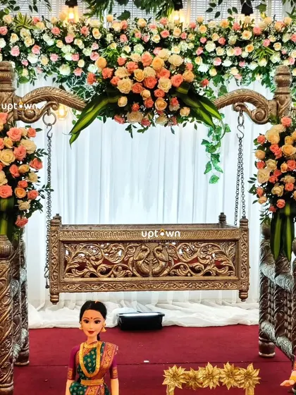 A close-up of the intricately carved wooden cradle decorated with flowers.