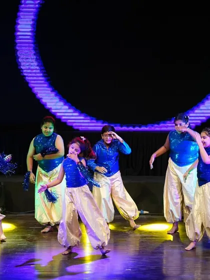 A playful moment from the kids' Bollywood dance, showcasing their expressions and filmy adas (style).