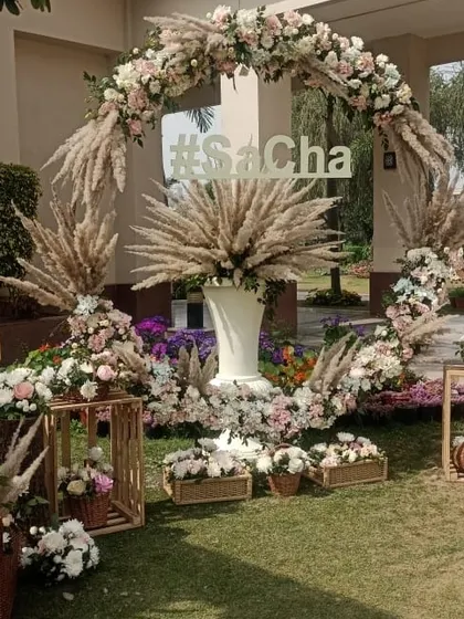 I design custom photo booths that become a highlight for guests. This one features a large floral ring made with pampas grass and pastel roses, complete with the couple's wedding hashtag, making it a perfect spot for social media shares.
