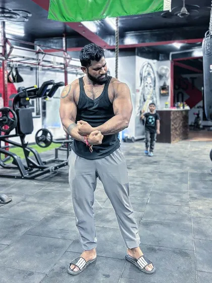 Professional in the gym, personal outside. A full-body pose showing the physique I've built.