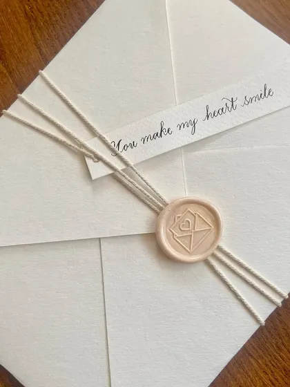 Nothing beats a classic black and white palette. This handwritten letter to a fiancé is minimal and timeless, with a simple name tag and a custom wax seal that says "You make my heart smile."