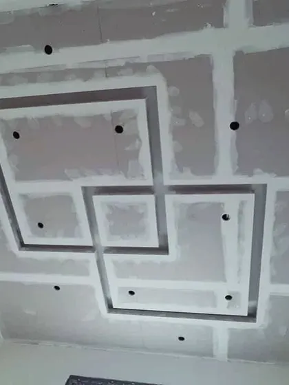 A maze-like geometric pattern being constructed with gypsum board. This shows the structural integrity of the design before it's smoothed over with POP.
