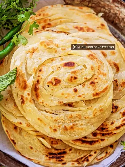 Experience the soft, flaky layers of our authentic Kerala Parotta. This South Indian bread is expertly prepared and serves as the perfect accompaniment to our range of vegetarian curries.