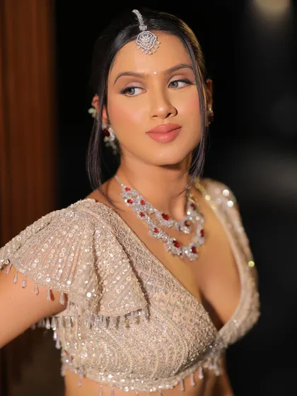 A three-quarter profile view of this soft bridal glam look. It highlights the cheek contour, the jawline, and the elegant hairstyle.