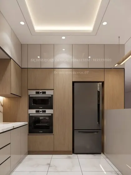 Another view of the U-shaped kitchen, showing the tall unit for the refrigerator and the seamless integration of appliances. The false ceiling provides excellent task lighting.
