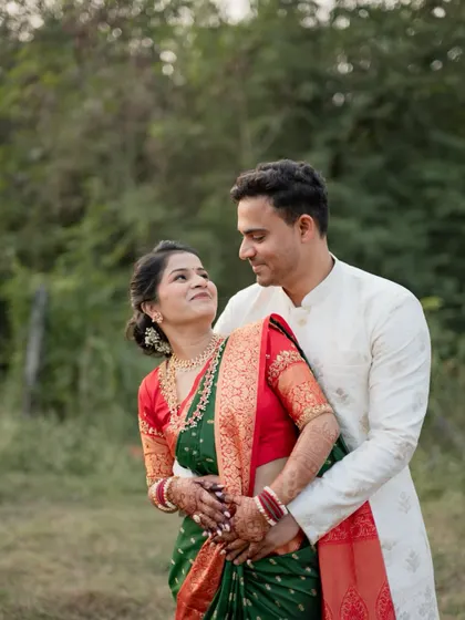 The groom-to-be embraces his fiancée from behind as they share a loving gaze in this romantic engagement portrait.