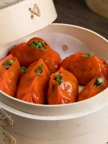Warm up with a selection of my perfectly crafted dim sum. These orange-hued dumplings are steamed to perfection and garnished with fresh spring onions.