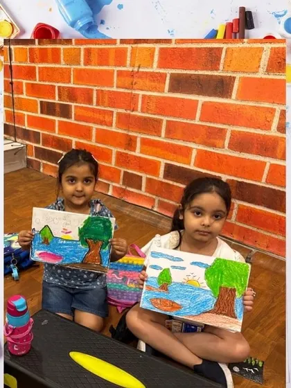 Two students show their matching landscape drawings. Working on similar projects helps them learn from each other and build friendships.