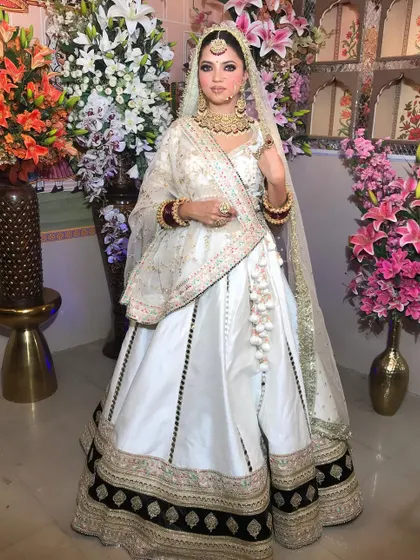 A front-facing view of the white Anarkali lehenga, highlighting the delicate embroidery on the blouse and the matching dupatta.