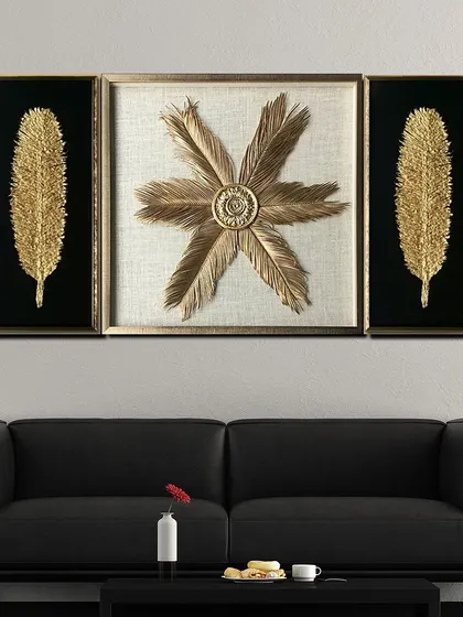 This set of three shadow boxes features golden feathers and a feather blossom. The contrast of the black and white backgrounds makes the golden 3D elements pop, adding a touch of natural elegance to your decor.