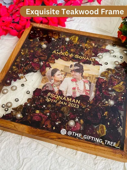 This 10x10 inch square teakwood frame is filled with preserved red rose petals and pearls, creating a beautiful memory of a wedding day.