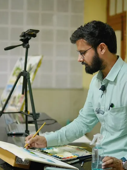 Demonstrating brush techniques on paper during the IIT BHU workshop, with the setup recorded for a clear view.
