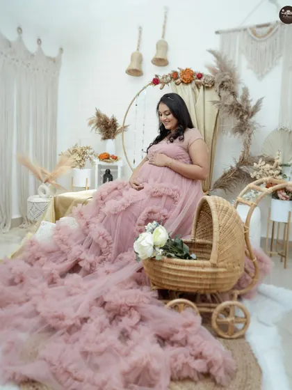 A full view of the boho-chic maternity setup, featuring a beautiful ruffled gown and a charming wicker baby pram. This style is perfect for creating whimsical and romantic pregnancy photos.