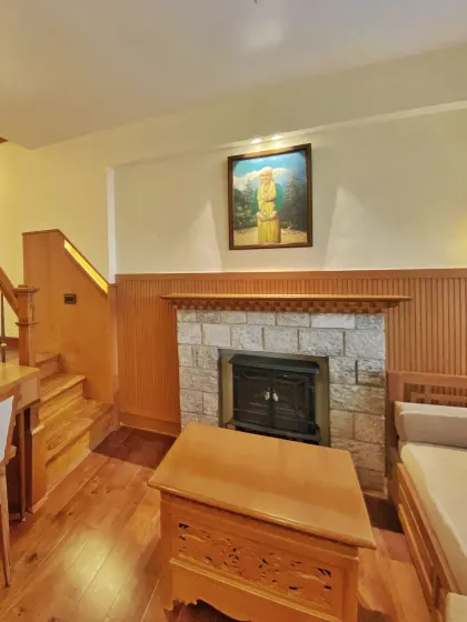 The cozy seating area in the Gangtok suite, complete with a stone-clad fireplace. This space is designed to be a warm retreat after a day of exploring the mountains.