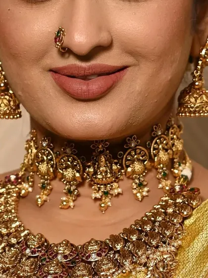 A detailed shot of a classic temple jewellery choker and jhumkas. The Lakshmi motif is a timeless design for bridal wear.
